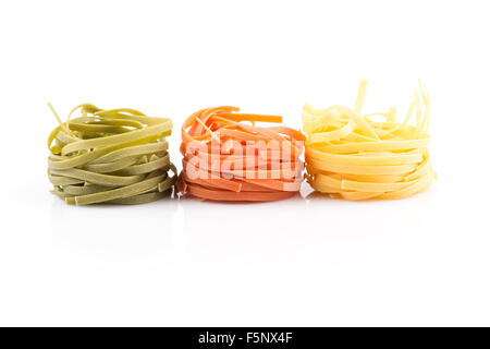 Tre colori nido di rotolo di pasta su uno sfondo bianco Foto Stock