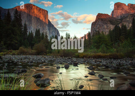 Tramonto in Yosemite Valley con l'ultima luce colpendo El Capitan e un riflesso nel fiume Merced Foto Stock