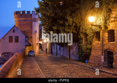 Podmurna street di notte e il Ponte della Torre di Porta nella città medievale di Torun, Polonia. Foto Stock