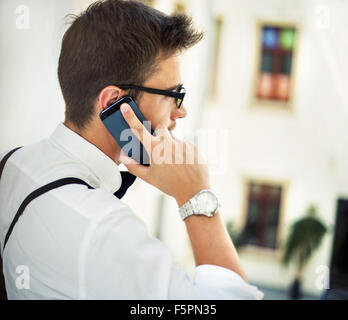 Giovane ragazzo parla al telefono cellulare Foto Stock