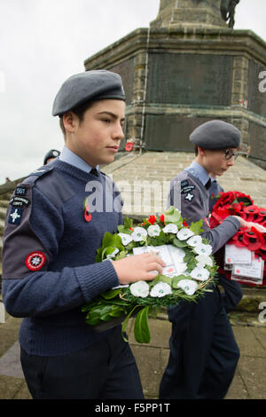 Aberystwyth, UK. 8 Novembre, 2015. Centinaia di persone si sono radunate per pagare i loro rispetti ai morti delle due guerre mondiali e altri conflitti al ricordo annuale cerimonia di domenica al piede di Aberystwyth iconici memoriale di guerra sul promontorio proteso verso il mare. Sia il bianco e il rosso papavero corone sono state previste durante la cerimonia, dai rappresentanti della legione britannica, il consiglio comunale e il locale la pace e la giustizia rete. Dopo la cerimonia tutte le ghirlande sono state raccolte per tenerli al sicuro davanti a gale force venti che sono previsioni meteo per colpire la costa occidentale © keith morris/Alamy Foto Stock