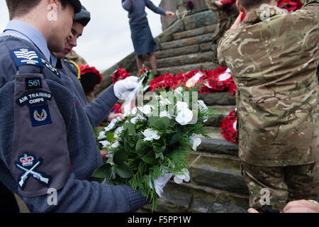 Aberystwyth, UK. 8 Novembre, 2015. Centinaia di persone si sono radunate per pagare i loro rispetti ai morti delle due guerre mondiali e altri conflitti al ricordo annuale cerimonia di domenica al piede di Aberystwyth iconici memoriale di guerra sul promontorio proteso verso il mare. Sia il bianco e il rosso papavero corone sono state previste durante la cerimonia, dai rappresentanti della legione britannica, il consiglio comunale e il locale la pace e la giustizia rete. Dopo la cerimonia tutte le ghirlande sono state raccolte per tenerli al sicuro davanti a gale force venti che sono previsioni meteo per colpire la costa occidentale © keith morris/Alamy Foto Stock