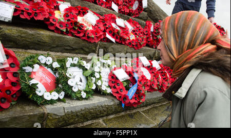 Aberystwyth, UK. 8 Novembre, 2015. Centinaia di persone si sono radunate per pagare i loro rispetti ai morti delle due guerre mondiali e altri conflitti al ricordo annuale cerimonia di domenica al piede di Aberystwyth iconici memoriale di guerra sul promontorio proteso verso il mare. Sia il bianco e il rosso papavero corone sono state previste durante la cerimonia, dai rappresentanti della legione britannica, il consiglio comunale e il locale la pace e la giustizia rete. Dopo la cerimonia tutte le ghirlande sono state raccolte per tenerli al sicuro davanti a gale force venti che sono previsioni meteo per colpire la costa occidentale © keith morris/Alamy Foto Stock