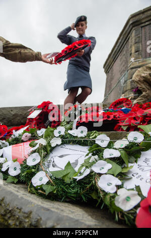 Aberystwyth, UK. 8 Novembre, 2015. Centinaia di persone si sono radunate per pagare i loro rispetti ai morti delle due guerre mondiali e altri conflitti al ricordo annuale cerimonia di domenica al piede di Aberystwyth iconici memoriale di guerra sul promontorio proteso verso il mare. Sia il bianco e il rosso papavero corone sono state previste durante la cerimonia, dai rappresentanti della legione britannica, il consiglio comunale e il locale la pace e la giustizia rete. Dopo la cerimonia tutte le ghirlande sono state raccolte per tenerli al sicuro davanti a gale force venti che sono previsioni meteo per colpire la costa occidentale © keith morris/Alamy Foto Stock