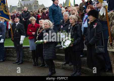 Aberystwyth, UK. 8 Novembre, 2015. Centinaia di persone si sono radunate per pagare i loro rispetti ai morti delle due guerre mondiali e altri conflitti al ricordo annuale cerimonia di domenica al piede di Aberystwyth iconici memoriale di guerra sul promontorio proteso verso il mare. Sia il bianco e il rosso papavero corone sono state previste durante la cerimonia, dai rappresentanti della legione britannica, il consiglio comunale e il locale la pace e la giustizia rete. Dopo la cerimonia tutte le ghirlande sono state raccolte per tenerli al sicuro davanti a gale force venti che sono previsioni meteo per colpire la costa occidentale © keith morris/Alamy Foto Stock