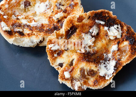 Hot imburrato, tè tostato torte su una piastra di colore blu Foto Stock