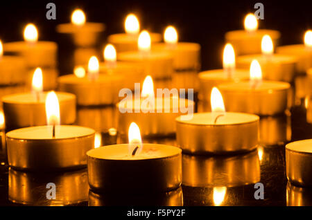 Primo piano di candele accese nelle tenebre Foto Stock