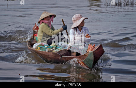 Cambogia barca persone. Due donne in barca sul fiume Tonle SAP Siem Reap villaggio galleggiante, Cambogia S. E. Asia Foto Stock