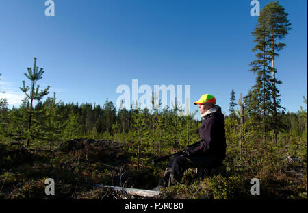 Femmina e giovane cacciatore di alci seduta nella foresta in attesa di alci. Foto Stock