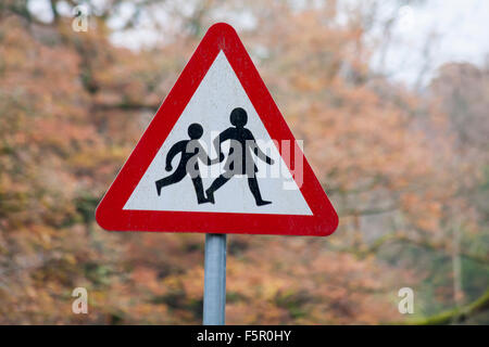 Cartello per il parco giochi, cartello per bambini che attraversano la strada, presso il villaggio Elan di Elan Valley, Powys, Mid Wales, UK a novembre - triangolo di segnaletica triangolare Foto Stock