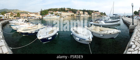 Barche a motore sono ormeggiate presso il porto di Kassiopi nella luce del mattino. Foto Stock