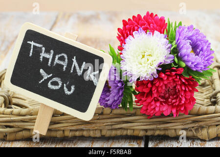 La ringrazio scritto sul piccolo blackboard e aster colorati mazzo di fiori Foto Stock