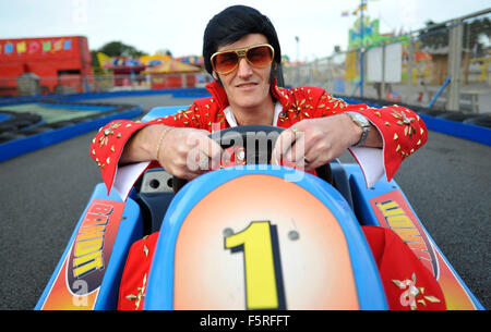 Un sosia di Elvis cavalca un go kart a Coney Beach Parco divertimenti in Porthcawl, nel Galles del Sud durante l'annuale festival di Elvis. Foto Stock