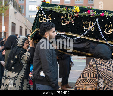 Jersey City, Stati Uniti. 08 Nov, 2015. Donne afferrare le frange della kafan la copertura nella devozione. Shia musulmani riuniti nella città di Jersey per commemorare il martirio di Hussein ibn Ali, il nipote del Profeta Maometto, partecipando a un Muharram processione dal luogo di scambio a City Hall a Montgomery Street. Credito: Albin Lohr-Jones/Pacific Press/Alamy Live News Foto Stock