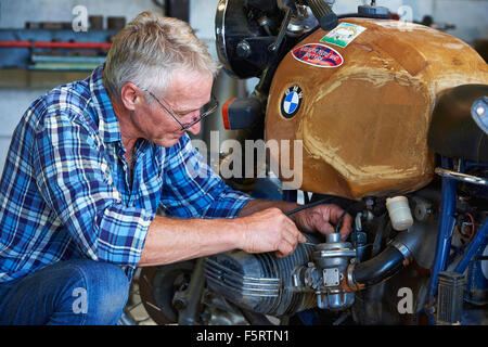 Coppia uomo più anziano di effettuare le regolazioni per la sua BMW Moto Foto Stock