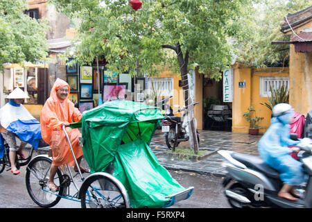 Hoi An old town in Vietnam. Stagione umida e piogge pesanti in città. Il cyclo rider cercando per il business Foto Stock