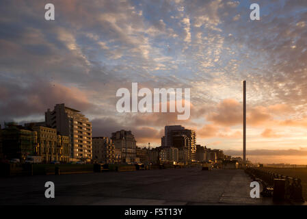 Sunrise a Brighton Seafront con i360 torre di avvistamento, mostra varietà di architettura, illuminato dal sole che sorge Foto Stock