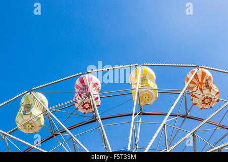 La sezione superiore di una ruota panoramica Ferris contro un cielo blu Foto Stock
