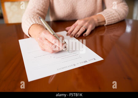 Senior donna firma Testamento, a casa Foto Stock