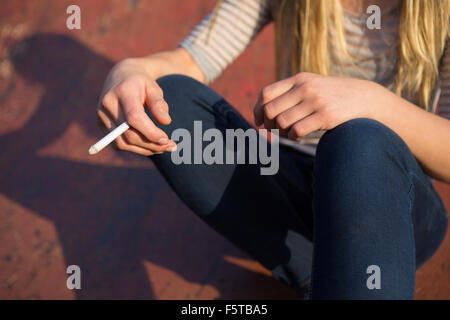 Close up della ragazza adolescente Sigaretta fumare all'aperto Foto Stock