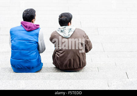Due ragazzi seduti sulle scale al di fuori Foto Stock