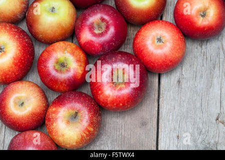 Mele rosse su sfondo di legno. Foto Stock