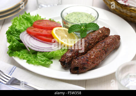 Carni di montone seekh kabab con chutney di menta isolati su sfondo bianco Foto Stock