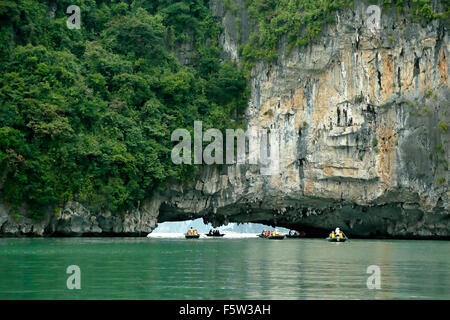 Turisti in fila in legno di barche e calcare (Carso grotta, Vung Vieng villaggio di pescatori, la baia di Ha Long, Bai Tu Long Settore, Vietnam Foto Stock