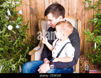 Papà aiutando figlio di decorare albero di natale Foto Stock