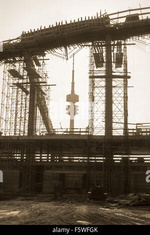 Il Parco Olimpico di Monaco di Baviera, sede dei Giochi Olimpici 1972, in fase di costruzione. Fernsehturm und Olympiastadion während der Bauzeit im Gegenlicht Foto Stock