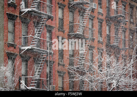 Facciata del Chelsea in mattoni con fuoco sfugge coperto di neve durante una nevicata invernale, Manhattan New York City Foto Stock