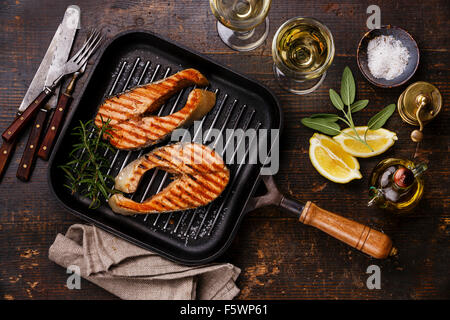 Salmone alla griglia bistecca su padella per grigliare su sfondo di legno con il vino Foto Stock