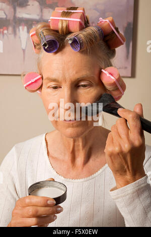 Donna di mezza età applicando foundation Foto Stock