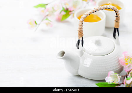 Il cinese Set per il tè e il ramo sakura sul tappetino di bambù Foto Stock