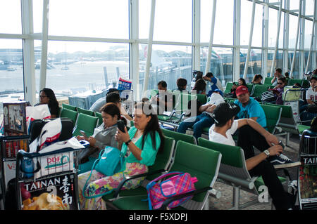 Passeggeri, lounge di partenza, l'Aeroporto Internazionale di Hong Kong, Chek Lap Kok, isola di Hong Kong Foto Stock