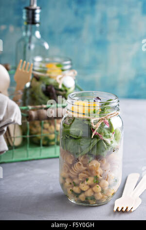 Assemblaggio di un mason jar insalata per un pranzo per andare Foto Stock