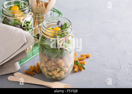 Assemblaggio di un mason jar insalata per un pranzo per andare Foto Stock