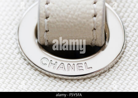 Chanel borsa designer. Close up di bianco con metallo argento Chanel nome circolare metallica di protezione del foro per la maniglia di trasporto. Foto Stock