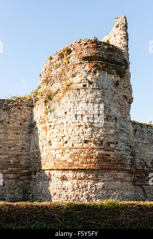 Inghilterra, romana del IV secolo Saxon Shore fort, Pavensey Castello. Resti del torrione rotondo e pareti di pietra. La seconda guerra mondiale la mitragliatrice fenditura nella parte superiore della torre. Foto Stock