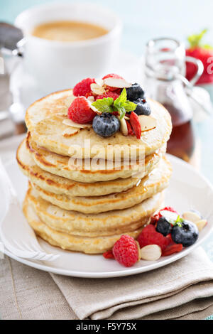 Soffici pancake di avena stack con frutti di bosco freschi, caffè e sciroppo Foto Stock