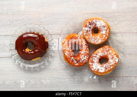 Ciambella con glassa di cioccolato e zucchero a velo rivestire Foto Stock