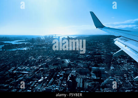 Volando sopra la città di Sydney con vedute del punto centrale, il Porto di Sydney e il Sydney Harbour Bridge Foto Stock