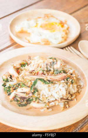 Il riso condito con stir-calamari fritti e basilico uovo fritto (cibo tailandese), stock photo Foto Stock