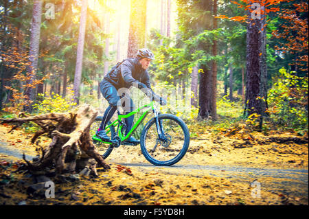 Mountain Biker a cavallo nella foresta di autunno Foto Stock