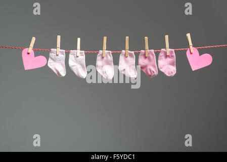 Baby girl calzini e cuore della carta sul stendibiancheria Foto Stock