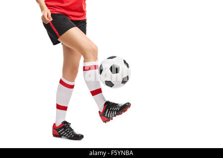 Close-up sulle gambe di una femmina di giocatore di football giocoleria con una sfera isolata su sfondo bianco Foto Stock