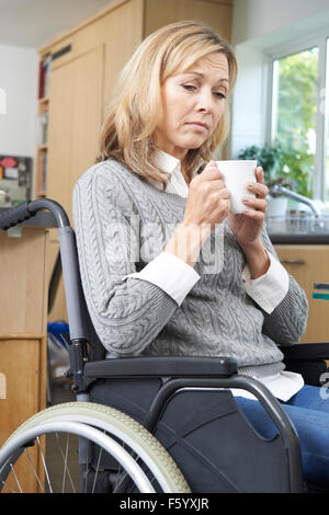 Premuto donna seduta in carrozzella a casa Foto Stock