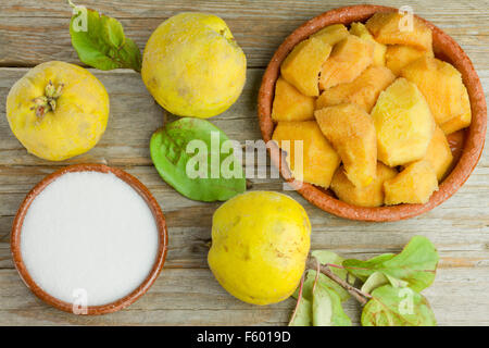 Le mele cotogne frutti e pasta di mela cotogna ingredienti su sfondo di legno Foto Stock