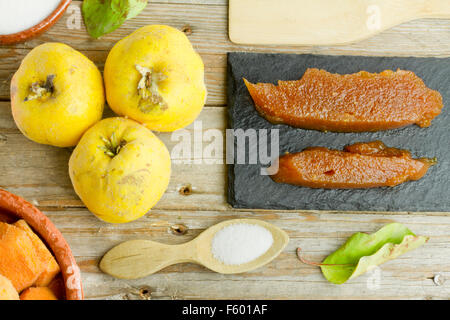 Lo spagnolo le mele cotogne frutti e pasta con gli ingredienti su sfondo di legno Foto Stock