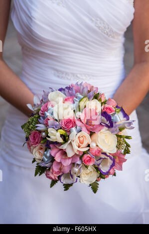 Bouquet rotondo con rose bianche, fresia e perle nelle mani della sposa Foto Stock